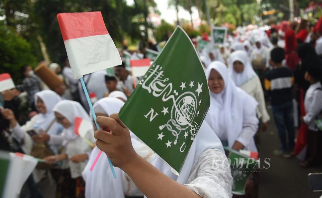 Bendera NU dan bendera merah putih dibawa anggota Fatayat NU saat mengikuti Karnaval Nusantara dalam rangka Satu abad Nahdlatul Ulama (NU) di Alun-alun Sidoarjo, Jawa Timur, Selasa (7/2/2023). 