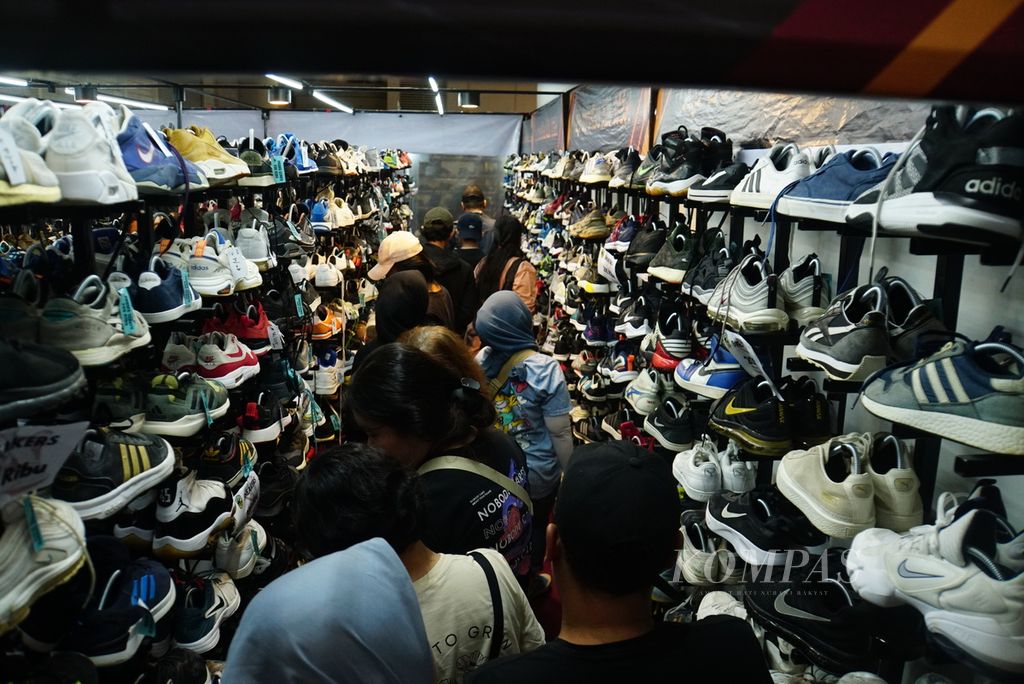 Pengunjung berdesakan untuk membeli sepatu di gerai Baper Store dalam gelaran cuci gudang Big Bang Festival 2023 di JIExpo Kemayoran, Jakarta, Kamis (28/12/2023). 