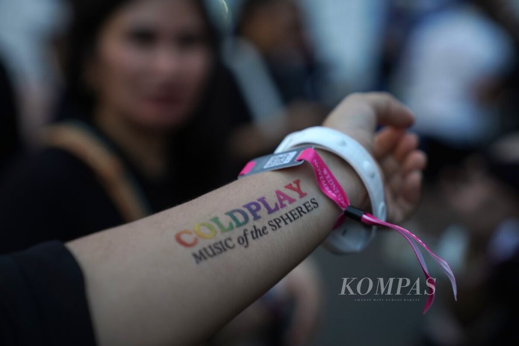 Penggemar grup band Coldplay menunjukkan tato temporer di Stadion Utama Gelora Bung Karno, Jakarta, Rabu (15/11/2023). Coldplay menggelar konser bertajuk ”Coldplay Music of the Spheres World Tour”. Tur dunia Coldplay, band asal London, Inggris, yang dibentuk tahun 1997 ini selalu menyedot animo besar penggemarnya di negara-negara yang disinggahinya.