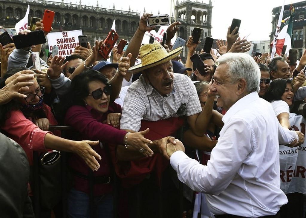 Presiden Meksiko Andres Manuel Lopez Obrador menyalami para pendukungnya saat melintasi Alun-alun Zocalo di pusat Mexico City, ibu kota Meksiko, Minggu (27/11/2022). 