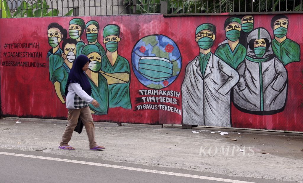 Warga melintas di depan mural yang berkaitan dengan maraknya pandemi Covid-19 yang berada di Jalan Raya Jakarta-Bogor, Depok, Jawa Barat, Minggu (5/4/2020). 