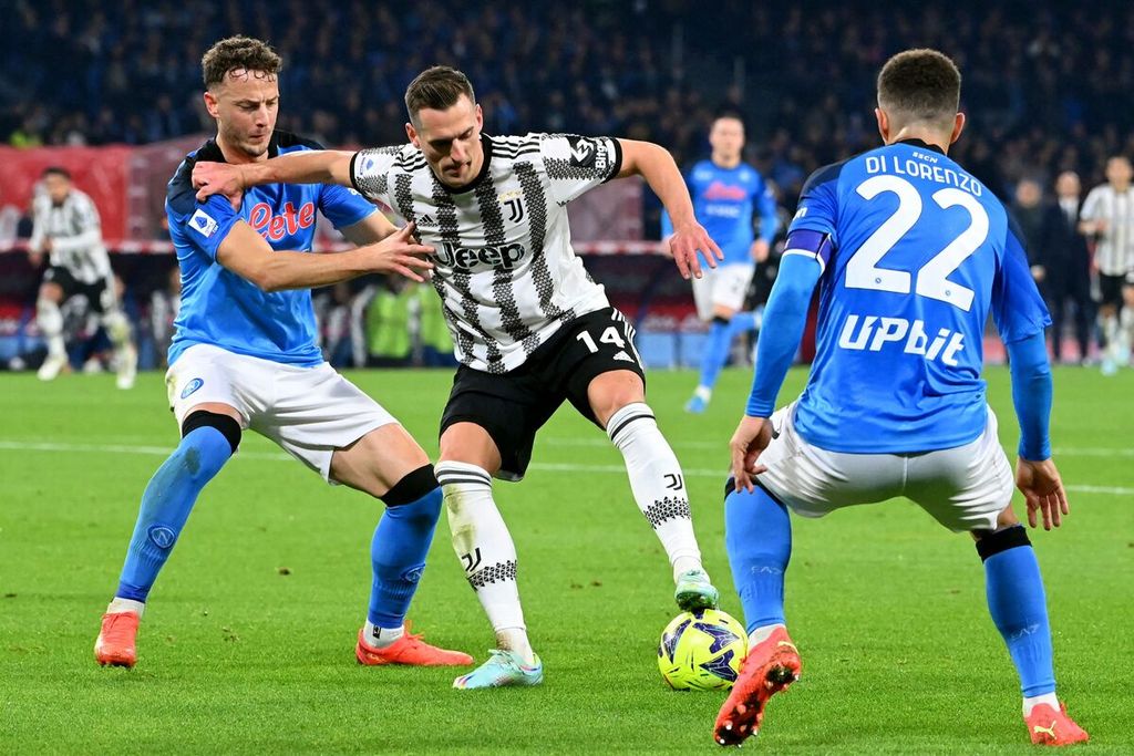 Penyerang Juventus, Arkadiusz Milik (tengah), dijaga oleh bek Napoli, Amir Rrahmani (kiri) dan bek Napoli Giovanni Di Lorenzo dalam pertandingan Liga Italia antara Napoli dan Juventus di Stadion Diego Maradona di Napoli, Sabtu (14/1/2023). Napoli mengalahkan Juventus, 5-1. 