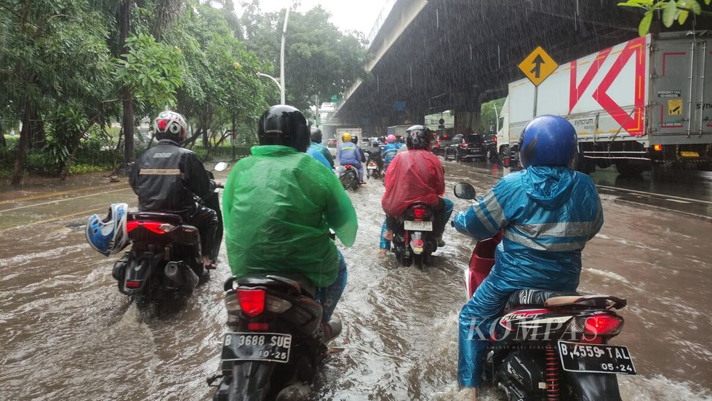 Pengendara sepeda motor berusaha melalui genangan air di Jalan Ahmad Yani, Cempaka Putih Timur, Jakarta Pusat, Kamis (29/2/2024). 