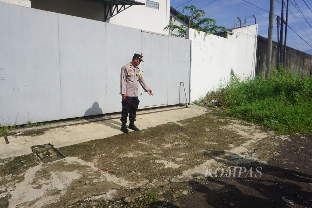 Anggota Kepolisian Resor Kota Banyumas menunjukkan ceceran darah korban penembakan di dekat tempat parkir Hotel Braga, Sokaraja, Banyumas, Jawa Tengah, Sabtu (27/4/2024).