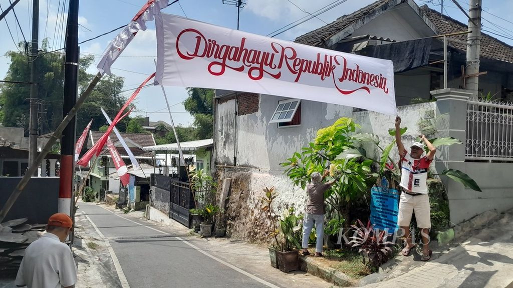 Residents unfurl the Happy Independence Day banner. Even though August is still less than two days away, the euphoria of the citizens in welcoming Indonesia's Independence Day is already felt. They raised funds for the purchase of decorations, such as paint.