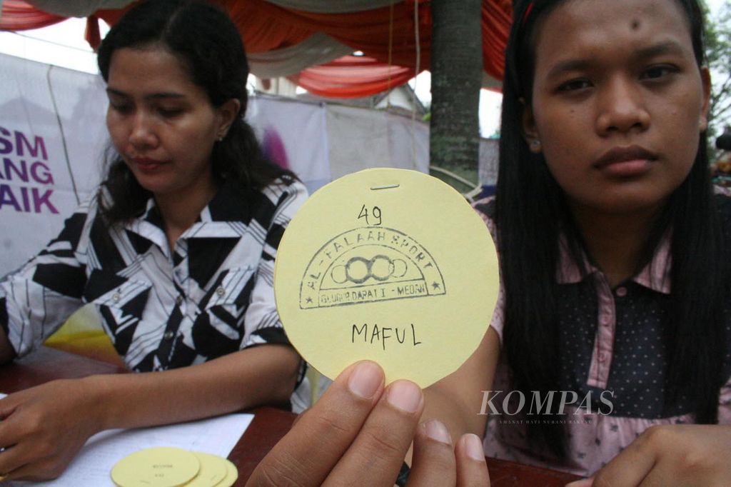 Seorang warga Kelurahan Glugur Darat, Kecamatan Medan Timur, Kota Medan, menunjukkan kupon berhadiah di pintu keluar TPS 9, Rabu (8/7/2009). 