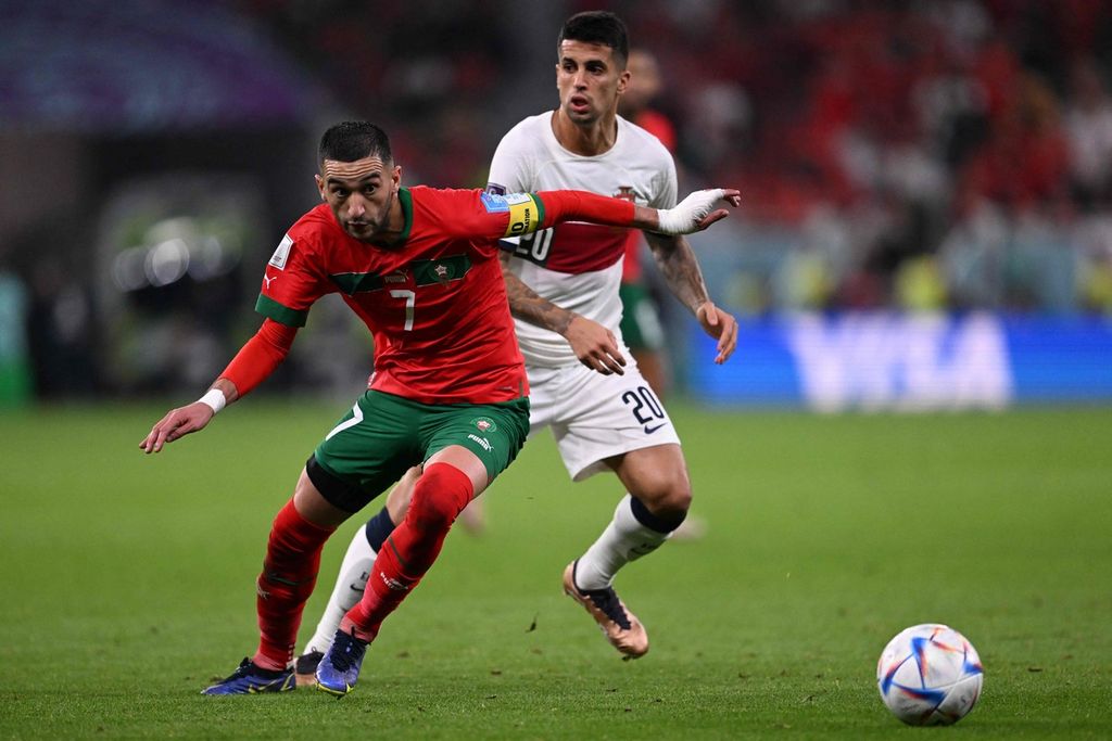 Sayap serang tim nasional Maroko Hakim Ziyech (kiri) mengecoh bek Portugal Joao Cancelo pada laga perempat final Piala Dunia Qatar 2022 antara Maroko dan Portugal di Stadion Al-Thumama, Doha, 10 Desember 2022.
