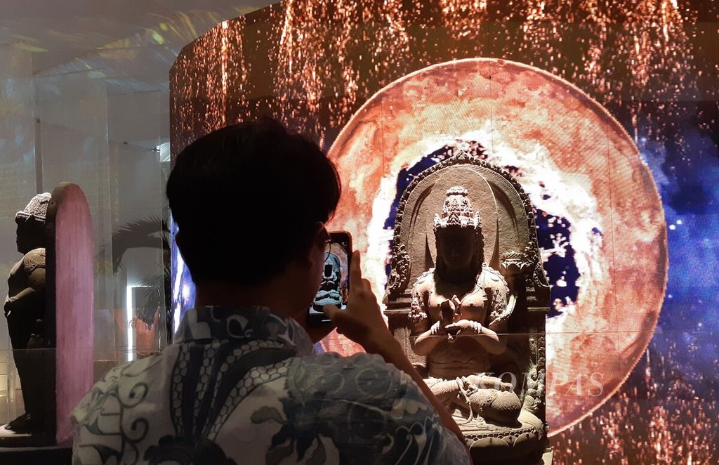 Pengunjung memotret arca Prajnaparamita peninggalan Kerajaan Singasari dalam pameran Repatriasi: Kembalinya Saksi Bisu Peradaban Nusantara, Jumat (1/12/2023). 