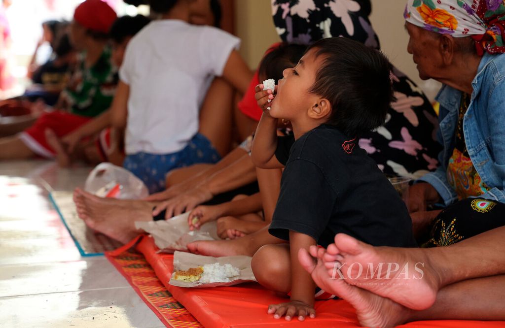 Anak-anak menikmati makan siang di tempat pengungsian, Kelurahan Joyotakan, Kecamatan Serengan, Kota Surakarta, Jawa Tengah, Jumat (17/2/2023). Banjir yang terjadi sejak Kamis sore terus bertambah tinggi seiring meluapnya beberapa sungai, salah satunya Bengawan Solo. Sebagian warga yang rumahnya terendam banjir sedalam 60 cm-150 cm mengungsi di sejumlah tempat, antara lain gereja, masjid, dan sekolah. 