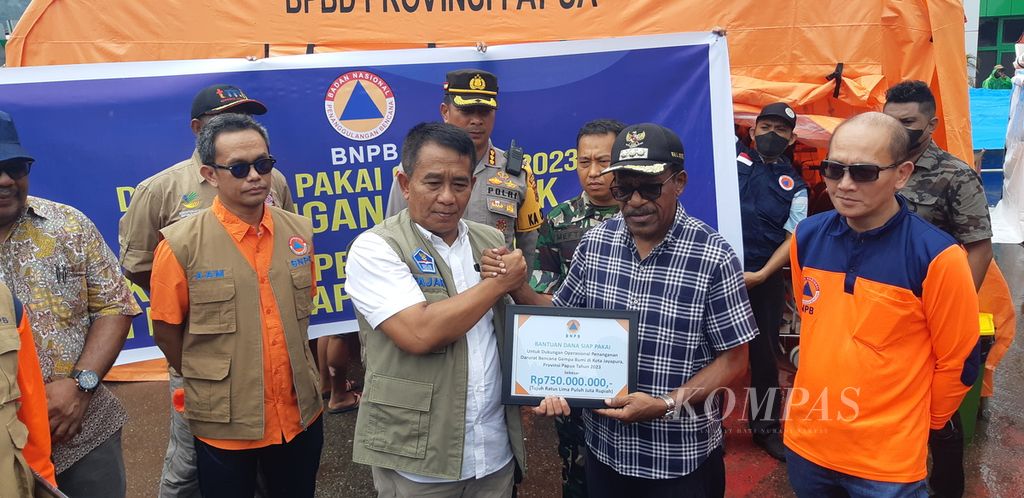 Deputi Badan Nasional Penanggulangan Bencana (BNPB) Mayor Jenderal Fajar Setyawan secara simbolis menyerahkan bantuan uang senilai Rp 1 miliar kepada Penjabat Wali Kota Jayapura Frans Pekey untuk penanganan dampak bencana gempa bumi di Jayapura, Papua, Sabtu (11/2/2023).