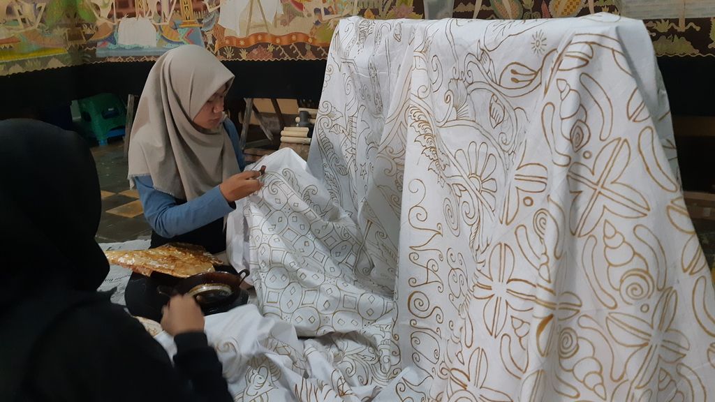 Pembatik sedang mengerjakan kain batik yang didesain oleh Dian Prymadika,di Batik Mahkota Laweyan, Kota Surakarta, Jawa Tengah, Jumat (30/9/2022) siang. Dian merupakan pembatik difabel yang berkarya di Batik Toeli Laweyan. Perusahaan batik tersebut mempekerjakan sejumlah difabel tuli lain seperti Dian.