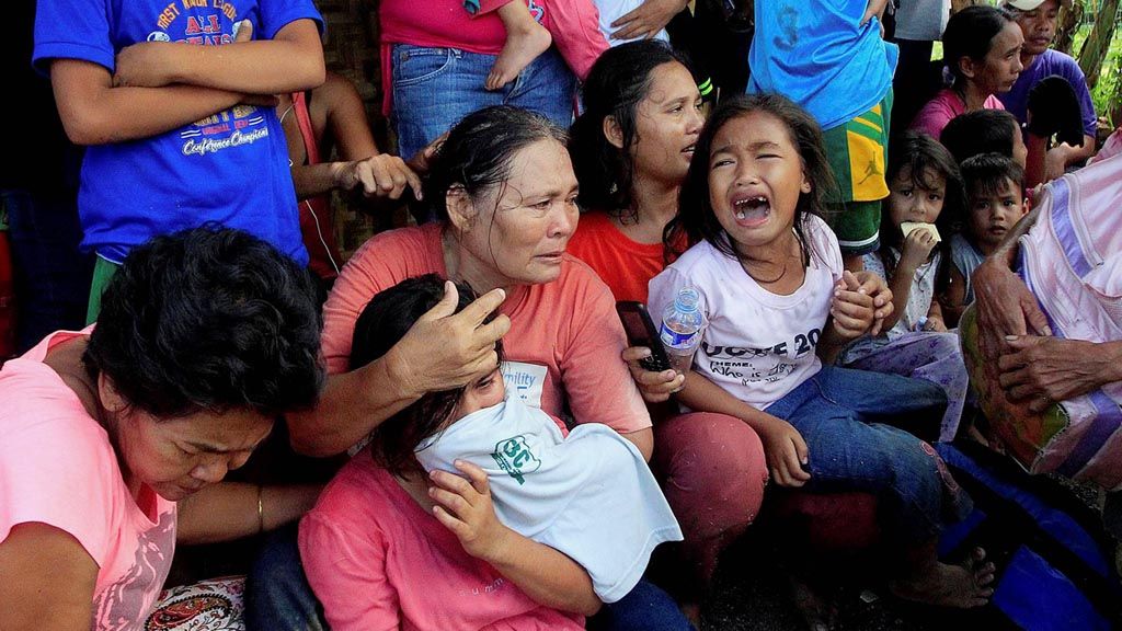 Warga  yang akan mengungsi menunggu kendaraan yang akan mengevakuasi mereka setelah kelompok militan BIFF  menduduki sebuah sekolah dan menyandera sejumlah warga sipil di Pigkawayan, North Cotabato, Pulau Mindanao, Filipina, Rabu (21/6). Milisi BIFF akhirnya mundur setelah baku tembak dengan pasukan pemerintah. 