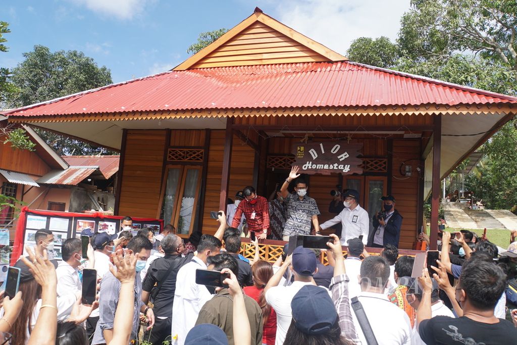 Warga berkumpul untuk melihat Menteri Pariwisata dan Ekonomi Kreatif Sandiaga Uno ketika mengunjungi salah satu rumah singgah milik warga di Desa Marinsow yang masuk area Kawasan Ekonomi Khusus Likupang, Minahasa Utara, Sulawesi Utara, Sabtu (6/3/2021). Sebanyak 211 <i>homestay </i>telah dibangun di tiga desa sekitar KEK Likupang.