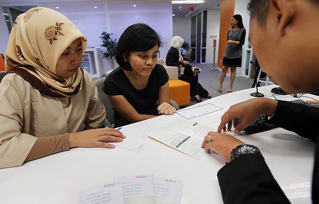 Pegawai Asuransi BNI Life menjelaskan tentang kegunaan asuransi bagi anak muda kepada calon nasabah di Jakarta, Senin (14/8).