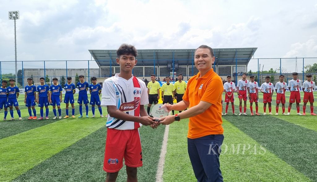 Ketua Komite Liga Kompas Kacang Garuda U-14 Adi Prinantyo menyerahkan plakat Pemain Terbaik Bulan Januari kepada gelandang Oneway Soccer School, Khairi Arbiansyah,