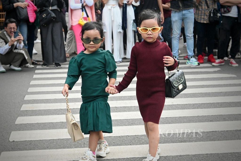 Dua anak kecil memamerkan aksi <i>fashion show</i> di daerah Dukuh Atas, Kecamatan Tanah Abang, Jakarta Pusat, Senin (25/7/2022) sore. Kawasan yang populer dengan sebutan Citayam Fashion Week ini terbentuk oleh remaja pinggiran yang nongkrong, berbusana kece, dan membuat konten aktualisasi diri.