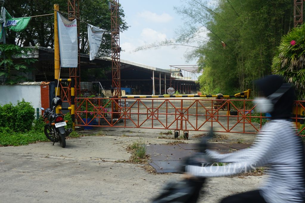 Seorang pengendara melewati sebuah pabrik karet di Palembang, Sumatera Selatan, bernama Badja Baru, Kamis (27/7/2023). Pabrik ini dinyatakan pailit pada 2022 karena merugi lantaran pasokan karet yang terus turun.