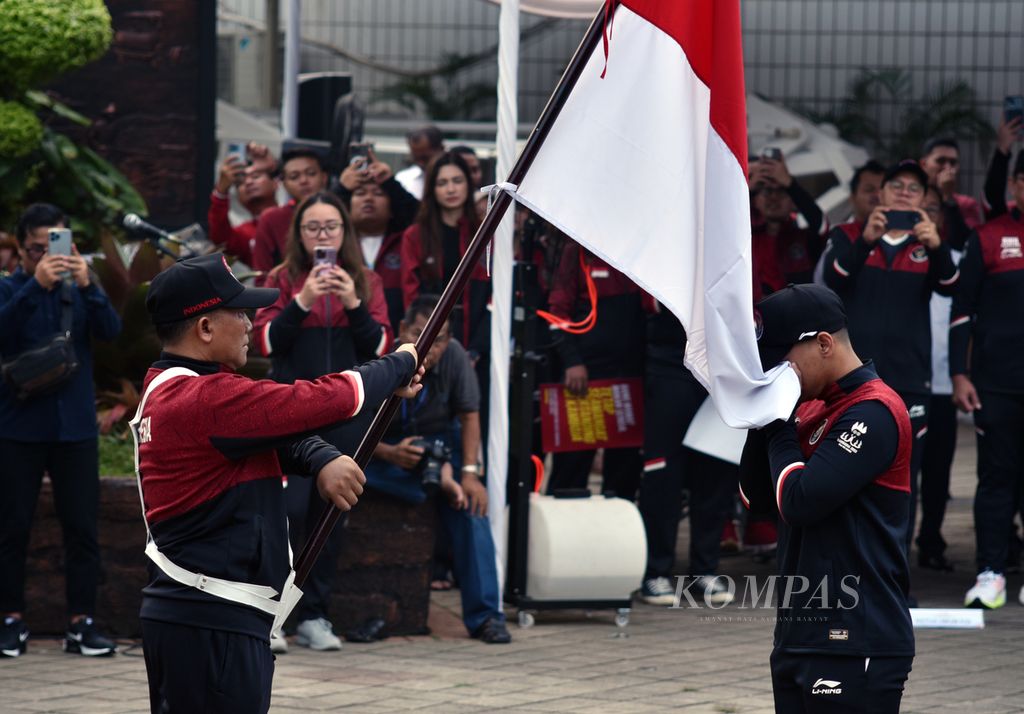 Karateka Indonesia, Ahmad Zigi Zaresta Yuda, menjalani ritual mencium bendera Merah-Putih dalam upacara pengukuhan kontingen Indonesia untuk SEA Games Kamboja 2023 di Kantor Kemenpora, Jakarta, Selasa (2/5/2023). 