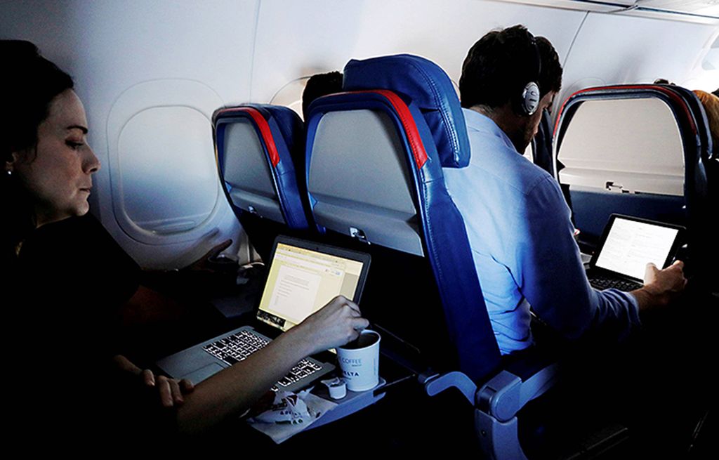 Dalam foto  yang diambil pada  26 Mei 2017 ini, para penumpang sedang menyalakan laptop dalam penerbangan dari Bandara Internasional John F Kennedy, di New York, AS. 