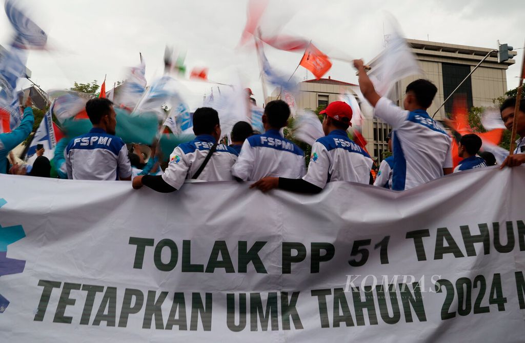 Pengunjuk rasa dari serikat buruh menggelar aksi menuntut kenaikan upah minimum kabupaten/kota tahun 2024 sebesar 15 persen di Jalan Pahlawan, Kota Semarang, Jawa Tengah, Kamis (30/11/2023). 