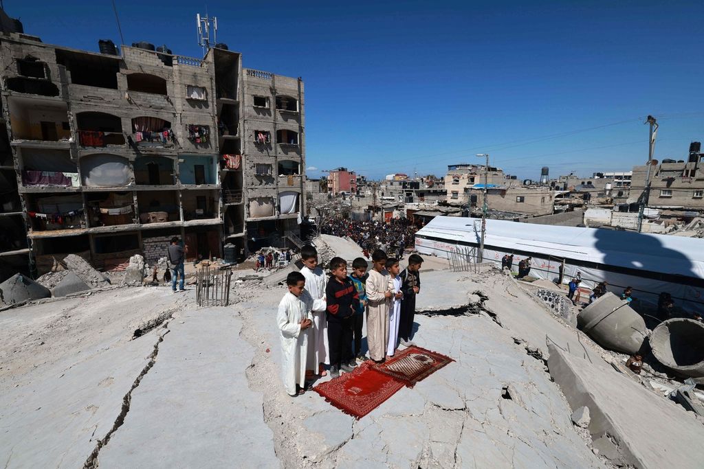 Anak-anak Palestina menunaikan shalat Jumat di reruntuhan Masjid Al-Farouq di Rafah, Jalur Gaza, pada Jumat (15/3/2024).