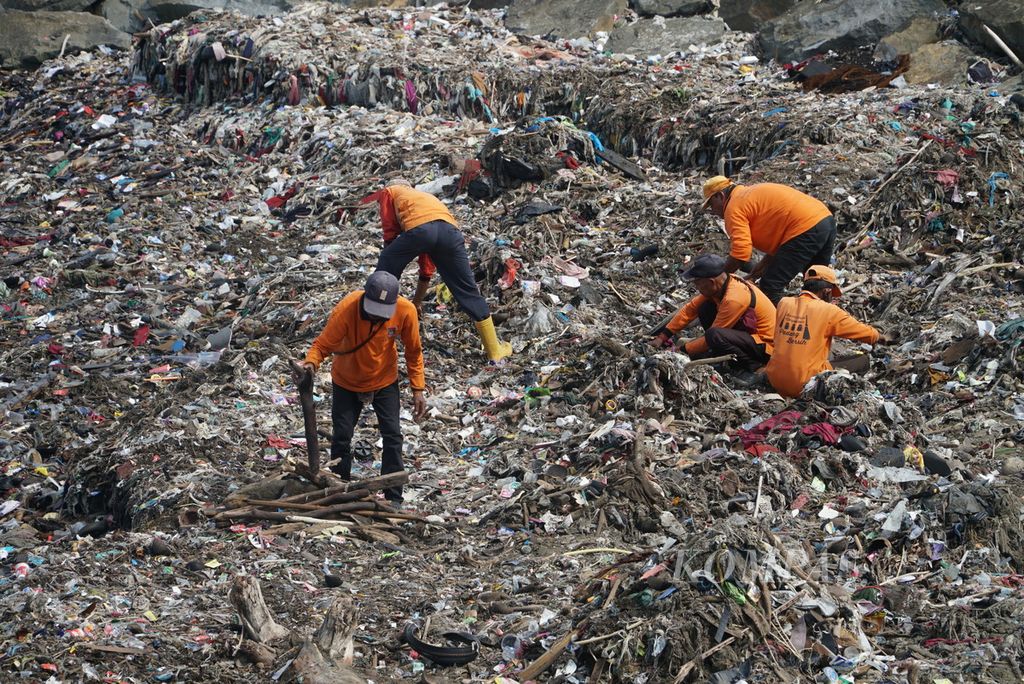 Petugas kebersihan membersihkan Pantai Padang dari tumpukan sampah, di Kelurahan Berok Nipah, Padang, Sumatera Barat, Sabtu (29/4/2023).