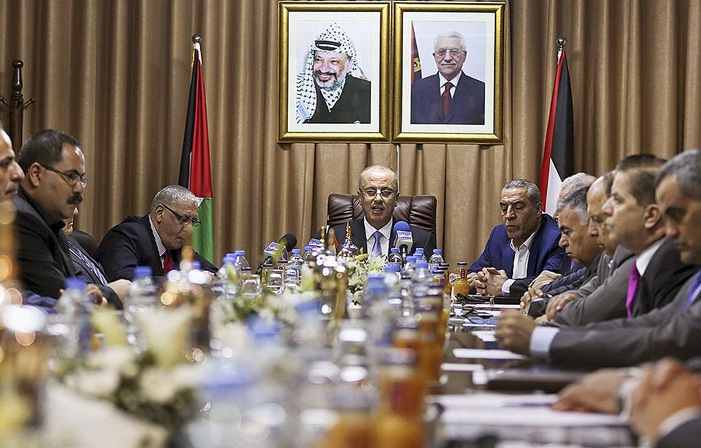 Perdana Menteri Palestina  Rami Hamdallah (tengah) memimpin rapat kabinet pemerintahan rekonsiliasi di Gaza City,   Palestina, Selasa (3/10). Hamdallah berkunjung ke Jalur Gaza dan memimpin rapat pemerintahan pertama di Gaza dalam upaya rekonsiliasi pemerintah yang mengakhiri 10 tahun perselisihan antara Fatah di Tepi Barat dan kelompok Hamas yang menguasai Jalur Gaza. 