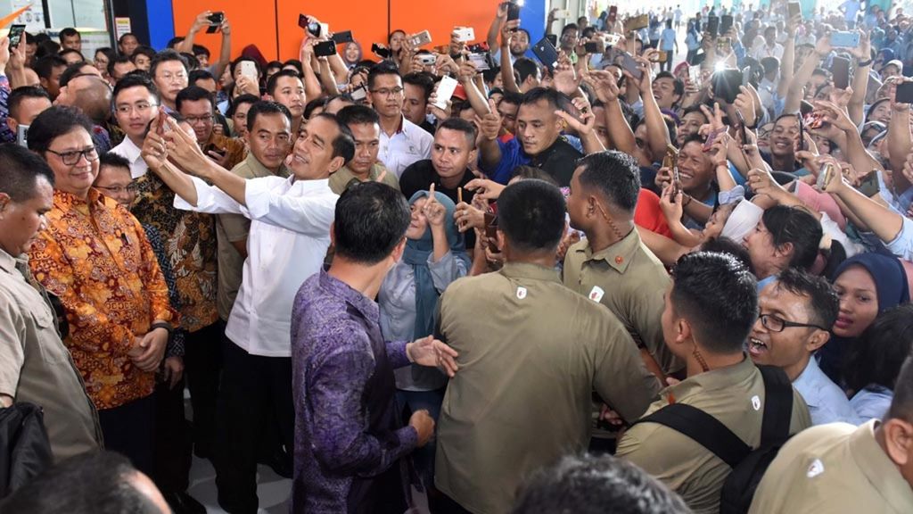 Presiden Joko Widodo berswafoto bersama para buruh yang bekerja di pabrik PT KMK Global Sports, Cikupa, Tangerang, Banten, Selasa (30/4/2019). 