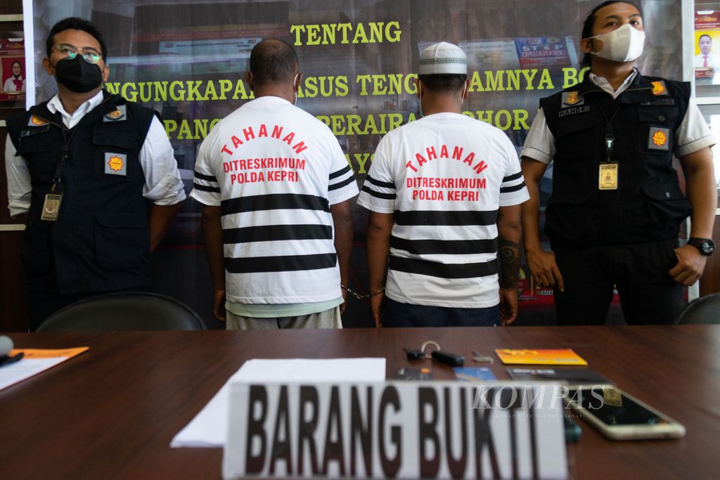 Dua anggota sindikat perdagangan orang yang terlibat dalam penyelundupan 64 pekerja migran yang menjadi korban dalam kecelakaan perahu tenggelam di perairan Johor, Malaysia, dihadirkan polisi saat rilis pers di Markas Polda Kepulauan riau, Batam, Senin (27/12/2021).