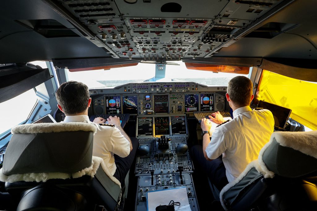 Pilot duduk di kokpit pesawat Emirates Airbus A 380-800, menyalakan salah satu mesin yang menggunakan 100 persen Bahan Bakar Penerbangan Berkelanjutan (SAF) sebelum penerbangan uji coba di Bandar Udara Internasional Dubai  pada 22 November 2023. 