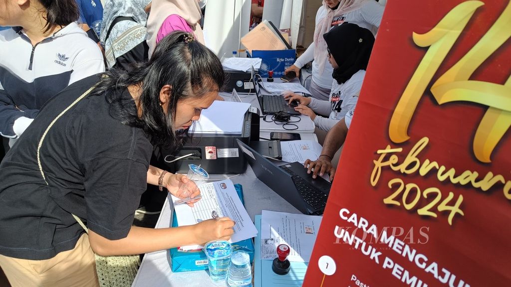 Seorang warga mengurus surat pindah memilih saat di kawasan hari bebas kendaraan bermotor di Bundaran HI, Jakarta, Minggu (14/1/2024).