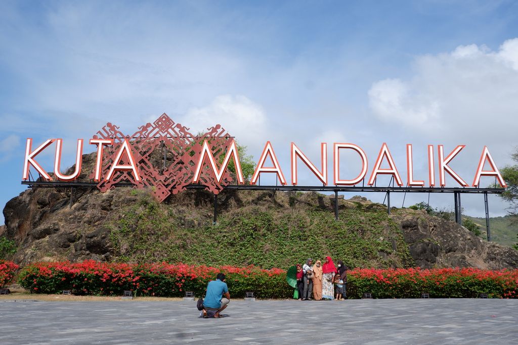 Wisatawan berfoto dengan latar belakang <i>land mark </i>Kawasan Ekonomi Khusus (KEK) Mandalika di Mandalika, Kuta, Pujut, Lombok Tengah, Nusa Tenggara Barat, Minggu (5/9/2021). KEK Mandalika saat ini menjadi salah satu destinasi superprioritas yang sedang dikembangkan Pemerintah Republik Indonesia. Dalam waktu dekat, sejumlah ajang internasional akan digelar di KEK Mandalika (Sirkuit Mandalika), yakni World Superbike, pada 12-14 November 2021 dan MotoGP pada Maret 2022.
