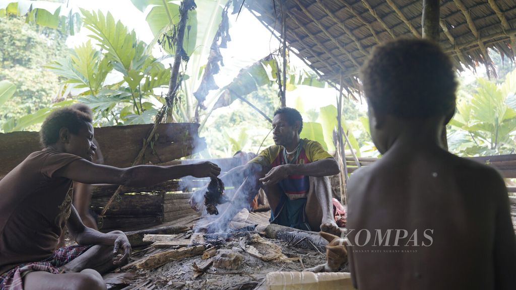  Ndahi Dayo, tetua suku Korowai, memasak bersama keluarganya di Dusun Dayo, Distrik Yanimura, Kabupaten Boven Digoel, Papua, Kamis (5/3/2020). Menurut Ndahi Dayo, tetua suku Korowai, rumah pohon dibangun tinggi untuk menghindari gigitan nyamuk dan gangguan roh jahat (<i>laloe</i>). 