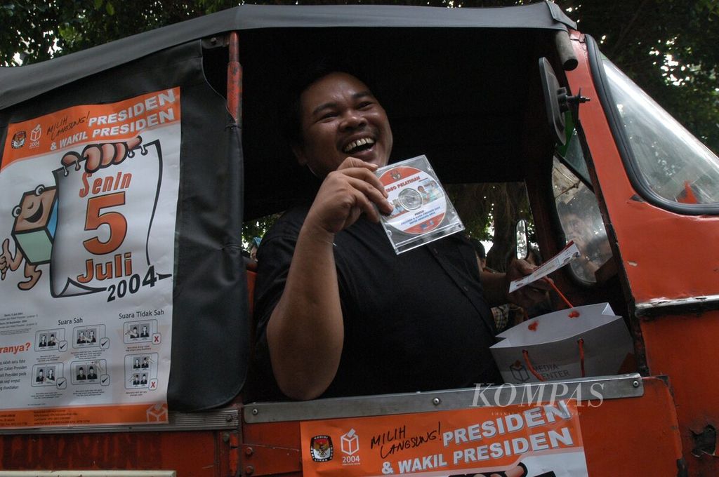 Nasrullah, also known as Mat Solar, famous for the comedy TV series Bajaj Bajuri, displays a VCD on his bajaj in front of the General Elections Commission building in Jakarta on Monday, June 14, 2004. The VCD launch, attended by actor Dedi Mizwar, contains training videos for presidential and vice presidential elections for members of the Polling Station Organizing Group (KPPS).