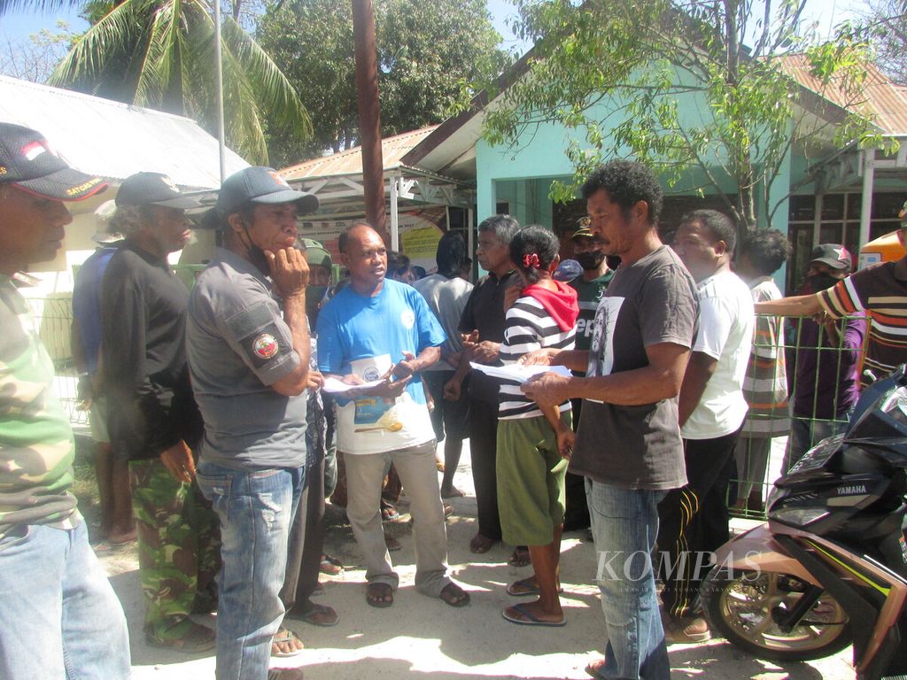 Koordinator Pengungsi Eks Timor Timur di Kamp Pengungsian Tua Pukan, Marcelino Lopes (topi) sedang menyimak laporan dari masing-masing warga soal kerusakan rumah akibat badai Seroja 2021 lalu. Mereka berharap, pemerintah memperhatikan nasip mereka yang selama ini terus terabaikan.