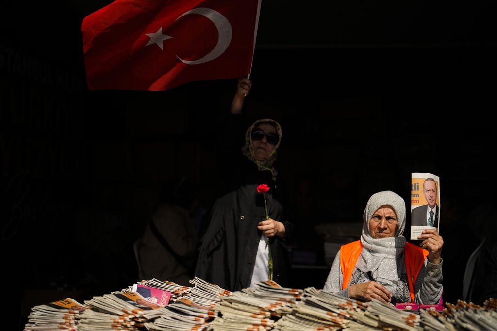 Pendukung Presiden Turki dan kandidat presiden dari Aliansi Kerakyatan, Recep Tayyip Erdogan, memberikan brosur kepada pelaju kereta di Istanbul, 23 Mei 2023. Para pemilih akan kembali ke bilik suara untuk pemilu putaran kedua, 28 Mei 2023. 