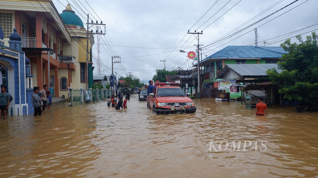 Mobil personel BPBD Kalsel menerobos banjir di Jalan Mistar Cokrokusumo, Kecamatan Cempaka, Kota Banjarbaru, Minggu (5/1/2020).