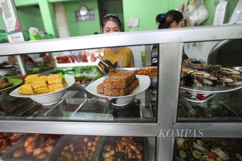 Pedagang melayani pembeli saat jam makan siang di warteg Jaya Bahari di kawasan Bintaro, Pondok Aren, Tangerang Selatan, Selasa (17/10/2023). UMKM makanan dan minuman merupakan para pelaku usaha yang paling banyak mengadopsi teknologi digital untuk mengembangkan usahanya. 