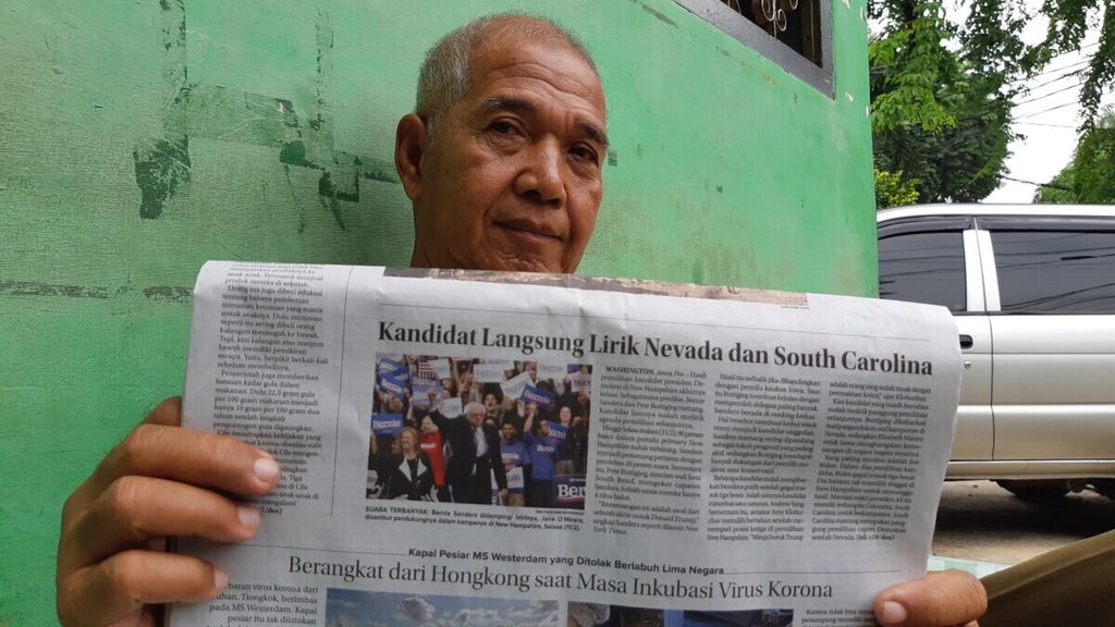 Warga Kebayoran Lama, Jakarta Selatan, membaca koran untuk mengetahui informasi terkini penyebaran virus korona  (13/2/2020).