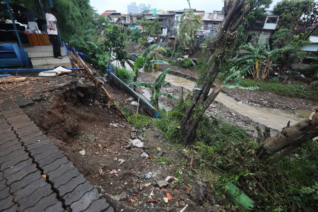 Batas paving blok yang longsor di bantaran Kali Ciliwung yang longsor di Kebon Manggis, Matraman, Jakarta Timur, Kamis (27/2/2020). Banjir yang menggenangi permukiman di sejumlah kawasan di Jakarta dan sekitarnya sebelumnya menyebabkan kawasan bantaran yang belum diturap beton tersebut longsor dan merusak bangunan di sekitarnya.