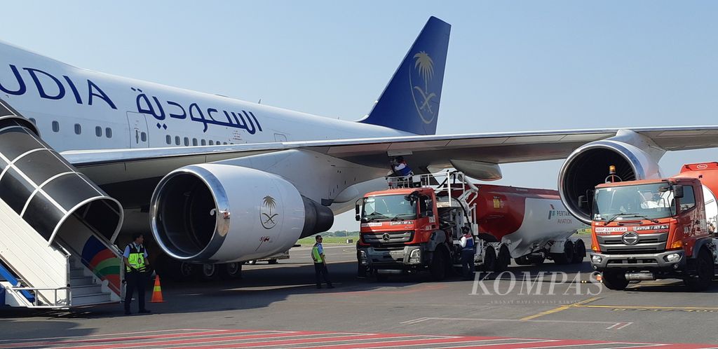 Petugas Pertamina mengisi bahan bakar minyak untuk pesawat atau avtur pada pesawat Saudi Arabia Airlines yang akan membawa ratusan jemaah haji embarkasi Surabaya kelompok terbang pertama, Rabu (24/5/2023). 