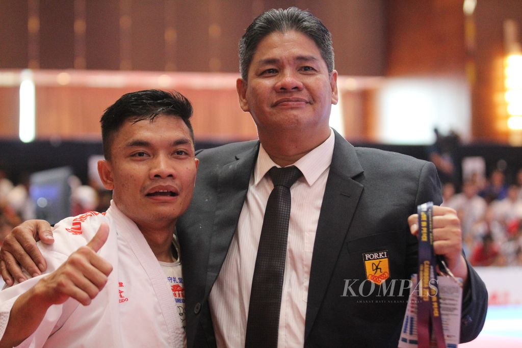 Sandi Firmansyah dipeluk pelatihnya usai memenangi pertandingan melawan karateka dari Filipina Christopher Chanco Agustin di Chroy Changvar Convention Center, Phnom Penh, Kamboja, Minggu (7/5/2023).