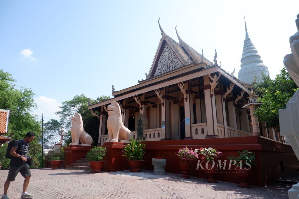 Wisatawan melintas di depan obyek wisata Wat Phnom yang berlokasi di Phnom Penh, Kamboja, Selasa (2/5/2023). Wat Phnom adalah kuil Buddha yang terletak di atas satu-satunya bukit di Phnom Penh. Legenda pendirian kuil ini tidak bisa dilepaskan dari asal-usul nama kota Phnom Penh.