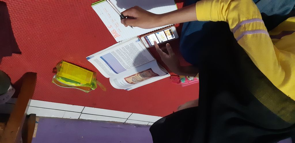 Seorang remaja murid SMP mempelajari bahan pelajaran yang dibagikan gurunya melalui dokumen daring di rumahnya, Senin (16/3/2020). 