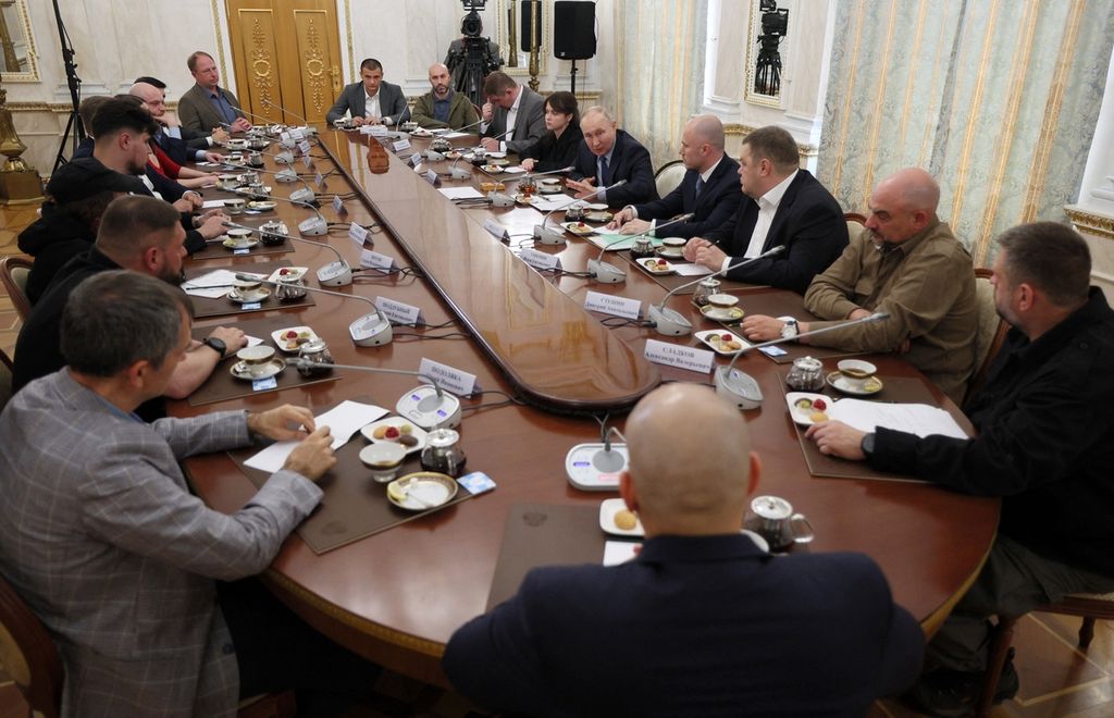 Presiden Rusia Vladimir Putin (lima dari kanan) bertemu dengan sejumlah jurnalis koresponden perang dan bloger di Kremlin, Moskwa, Selasa (13/6/2023). Dalam pertemuan itu, Putin mengeluarkan beberapa sinyal soal upaya baru Rusia untuk menaklukkan Ukraina.