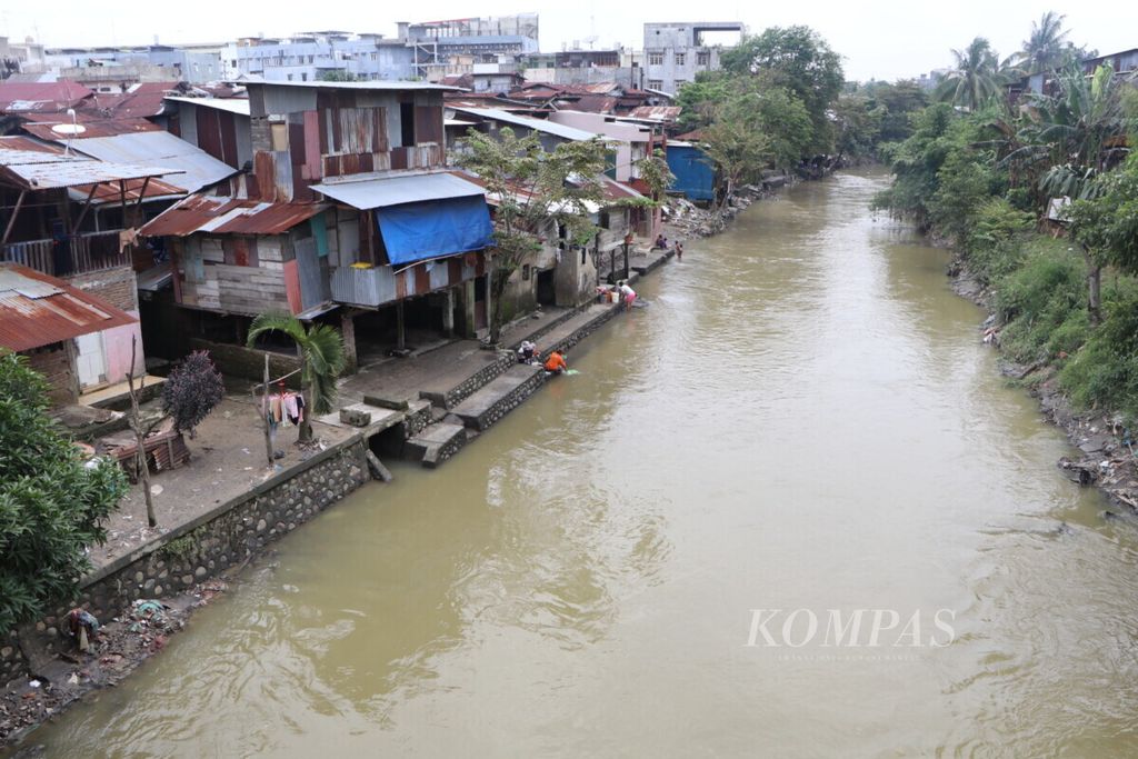 Masyarakat beraktivitas di bantaran Sungai Deli di sekitar Jalan Letjen Suprapto, Medan, Sumatera Utara, Rabu (24/11/2021). Sedimentasi sungai menjadi salah satu penyebab banjir yang semakin sering terjadi di Medan. 