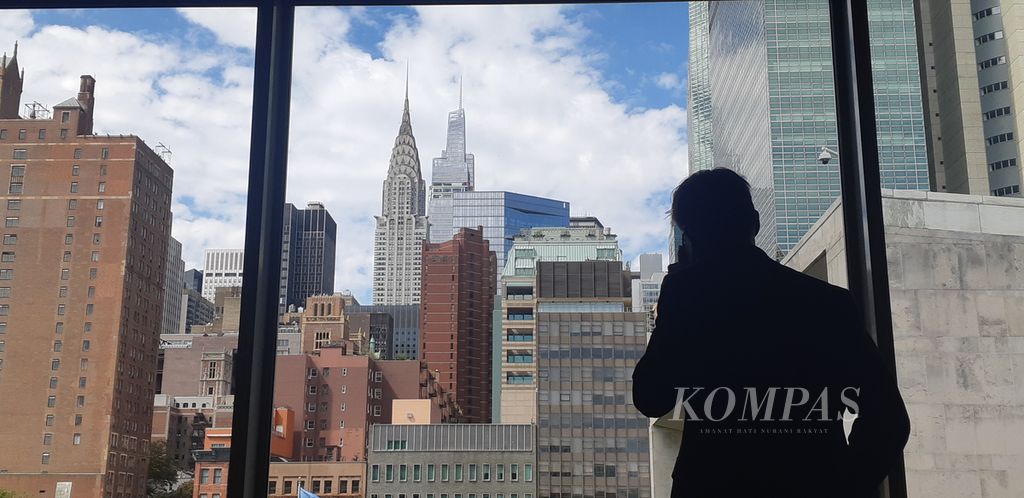 Salah seorang delegasi sedang berbicara melalui sambungan telepon dari dalam gedung PBB dengan latar belakang kawasan Manhattan, New York, Amerika Serikat, Minggu (18/9/2023).