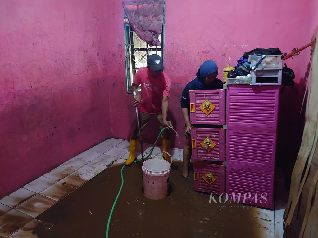 Warga yang terdampak banjir di Kelurahan Rajabasa Nunyai, Kecamatan Rajabasa, Kota Bandar Lampung, membersihkan rumah dari lumpur sisa banjir pada Minggu (25/2/2024) pagi. Warga mewaspadai adanya banjir susulan karena hujan deras masih terus mengguyur sebagian besar wilayah Lampung.