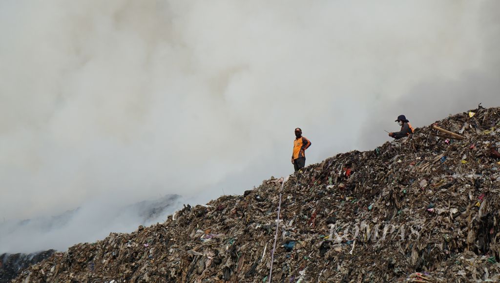 Petugas berupaya memadamkan kobaran api yang muncul pada tumpukan sampah yang menggunung, di TPA Putri Cempo, Kota Surakarta, Jawa Tengah, Sabtu (16/9/2023). 