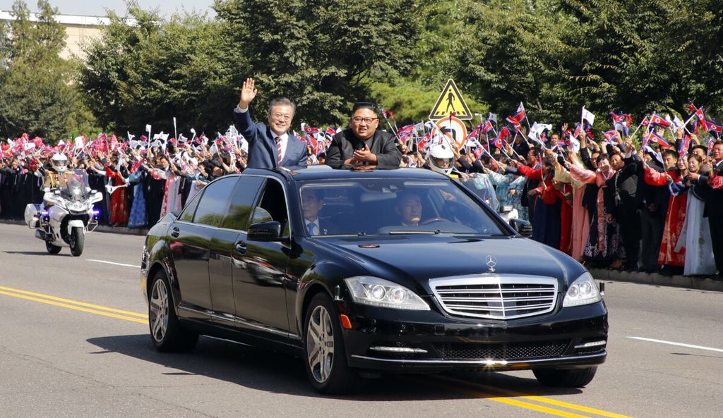 Presiden Korea Selatan Moon Jae-in (kiri) dan Pemimpin Korea Utara Kim Jong-un berdiri atas mobil dalam parade di Pyongyang, Korut, 18 September 2018. 